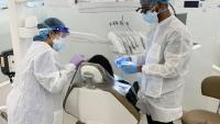Faculty member and dental assistant treat a patient